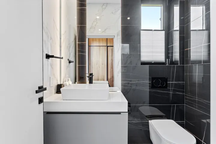 Bathroom with tile walls, vanity, and toilet