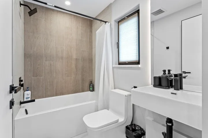 Bathroom featuring toilet and shower / bathtub combination with curtain