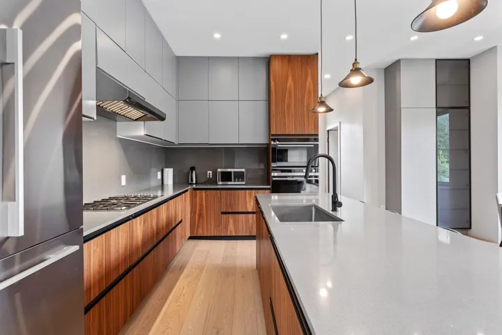 Kitchen with stainless steel appliances, modern cabinets, a sink, light wood finished floors, and recessed lighting