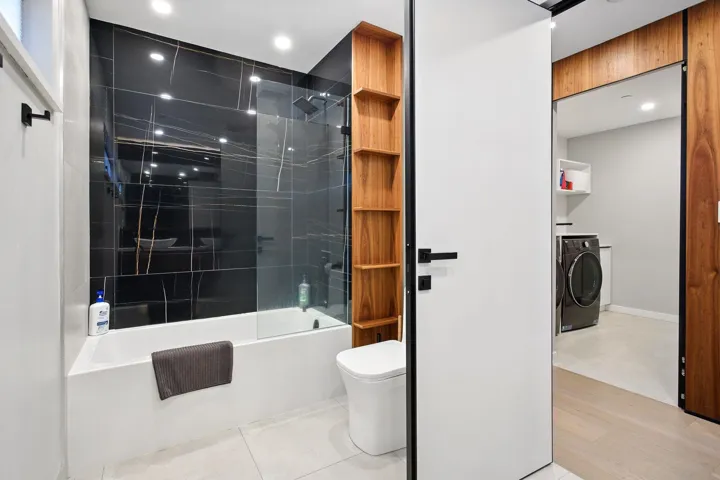 Bathroom featuring independent washer and dryer, toilet, shower / bathtub combination, recessed lighting, and tile patterned flooring