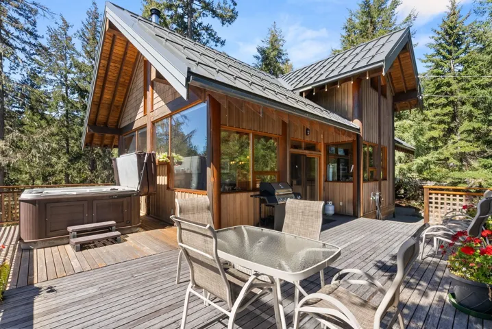 Deck featuring a hot tub, outdoor dining space, and grilling area