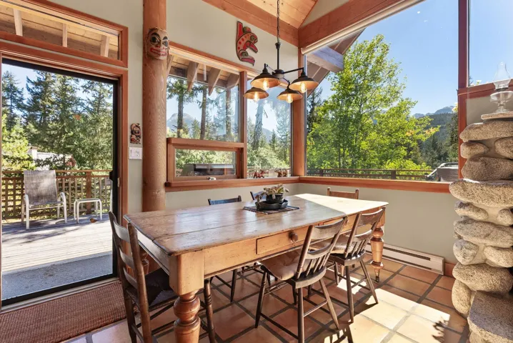 Tiled dining space featuring baseboard heating, a chandelier, and a mountain view