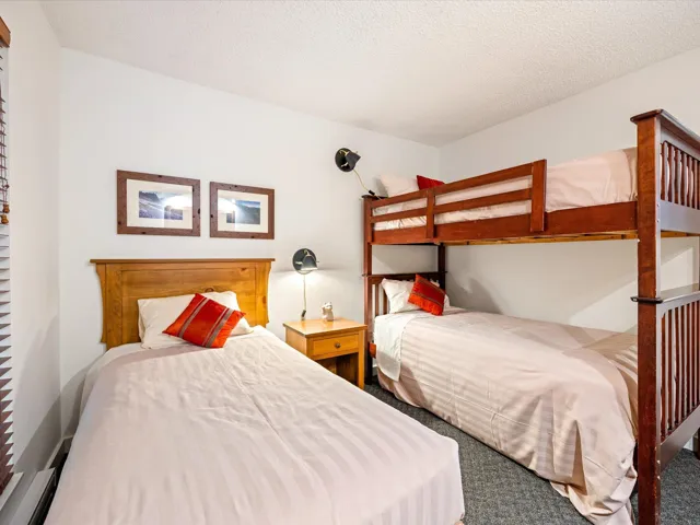 Carpeted bedroom with a textured ceiling and baseboard heating