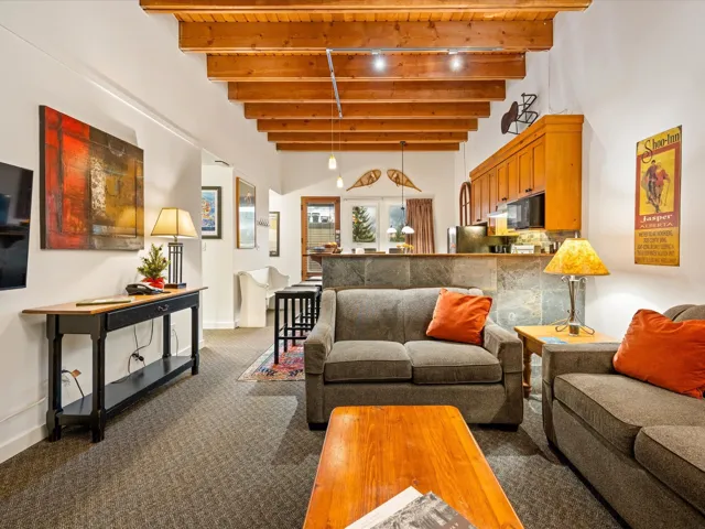 Living area featuring carpet and beam ceiling