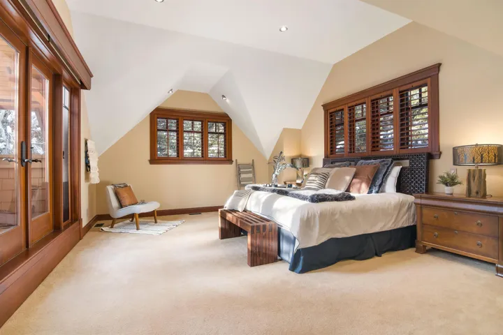 Carpeted bedroom with lofted ceiling and baseboards