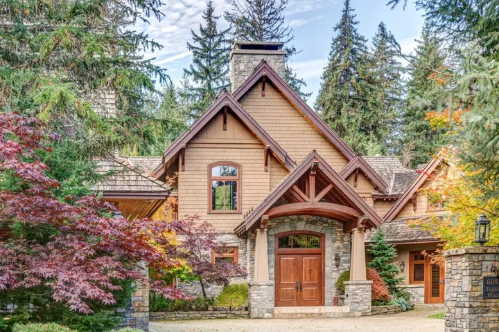 View of front of house featuring stone siding and a chimney