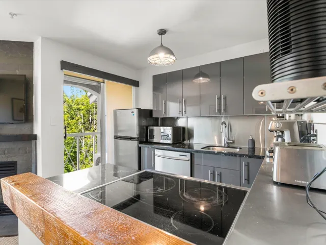 Kitchen with stainless steel appliances, gray cabinetry, pendant lighting, modern cabinets, and dark stone countertops