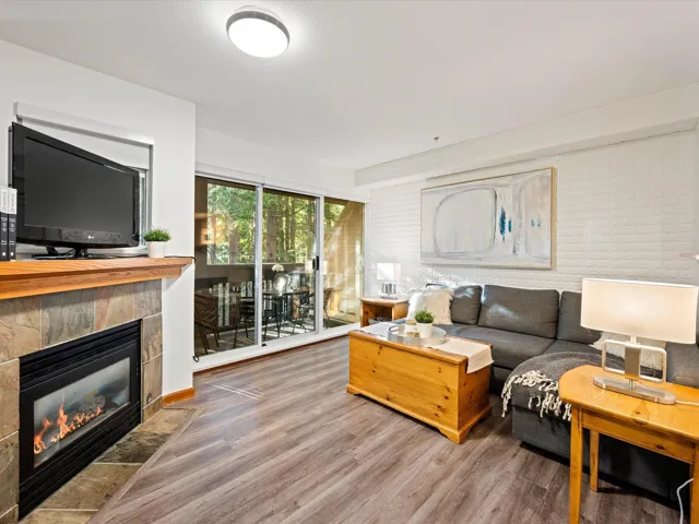 Living room with wood finished floors and a tile fireplace