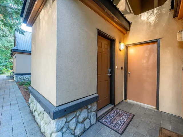 Doorway to property featuring stucco siding
