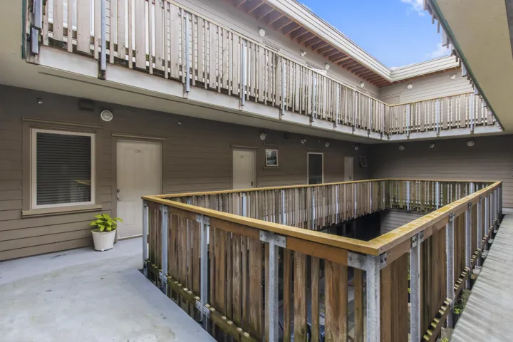 Multi-level building exterior featuring wood-sided walls and natural wood railings
