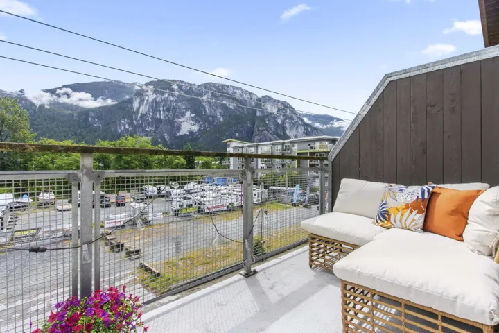 Private balcony featuring a metal railing and a dark wood-paneled exterior wall