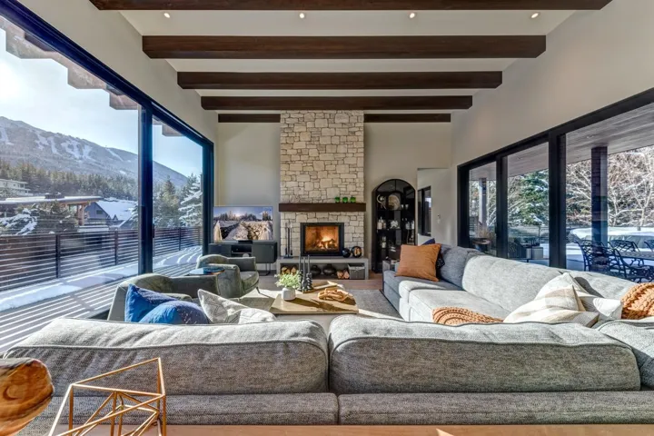 Living room with a mountain view, a fireplace, beam ceiling, and wood finished floors