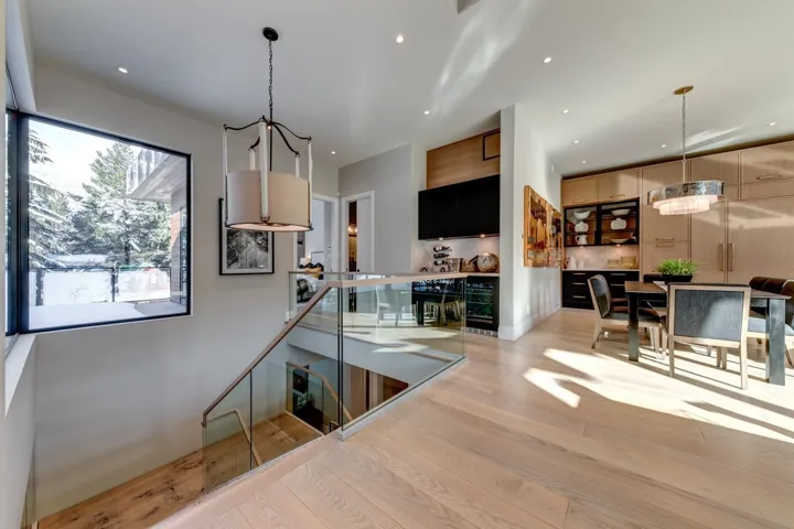 Staircase with wood finished floors, recessed lighting, and beverage cooler