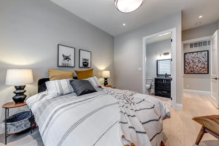 Bedroom with light wood-style flooring and ensuite bath