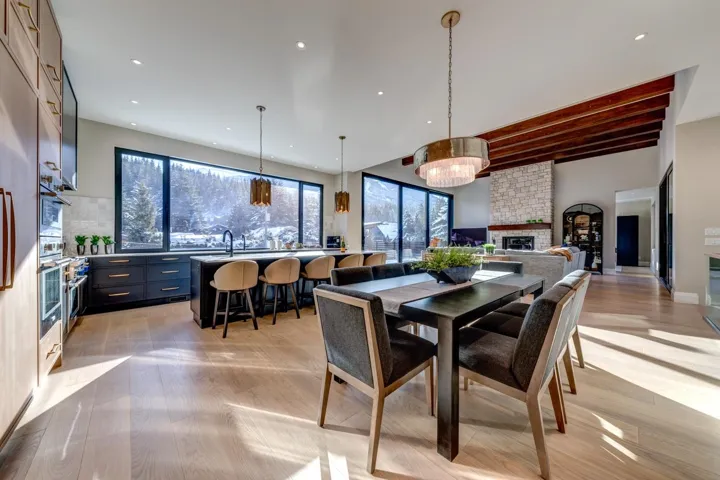 Dining room featuring beamed ceiling, light wood-style flooring, a brick fireplace, plenty of natural light, and recessed lighting