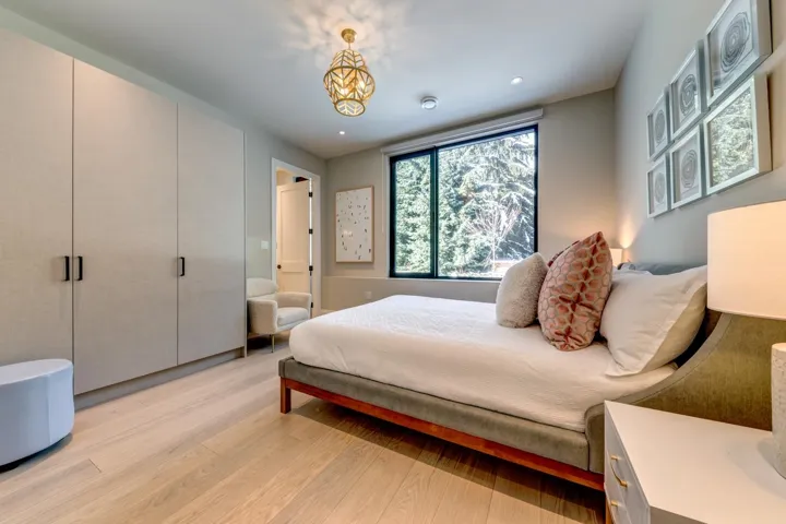 Bedroom featuring light wood-style floors, ensuite bathroom, a chandelier, and recessed lighting