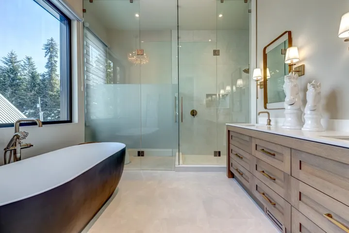 Bathroom featuring double vanity, a shower stall, a soaking tub, a chandelier, and light tile patterned floors