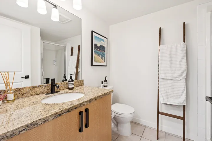 Bathroom featuring vanity, light tile patterned floors, and a shower stall
