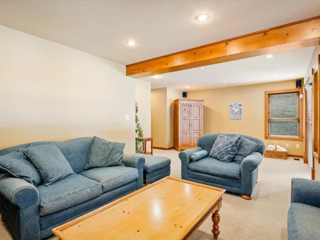 Living area featuring beam ceiling, recessed lighting, and light colored carpet