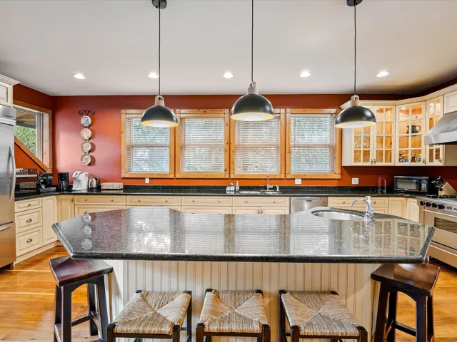Kitchen featuring cream cabinets, a sink, stainless steel appliances, and light wood-type flooring