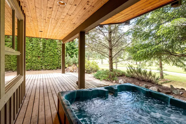 Wooden deck with an outdoor hot tub outside of the media room on the ground level