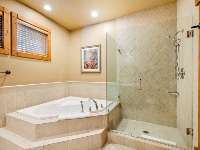 Full bathroom featuring recessed lighting, a bath, and a shower stall