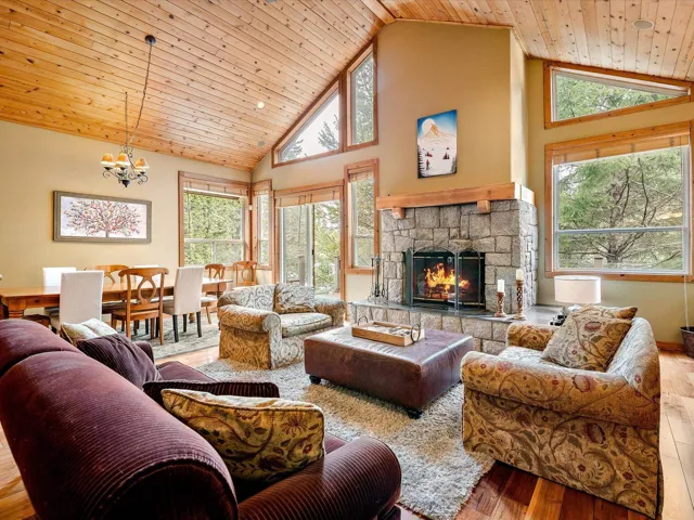 Living room with a fireplace, high vaulted ceiling, wood ceiling, and hardwood / wood-style floors