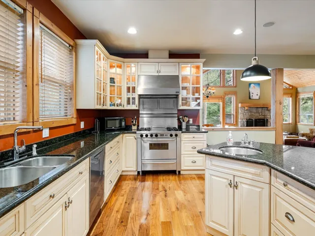 Kitchen featuring under cabinet range hood, a sink, stainless steel appliances, and light wood finished floors