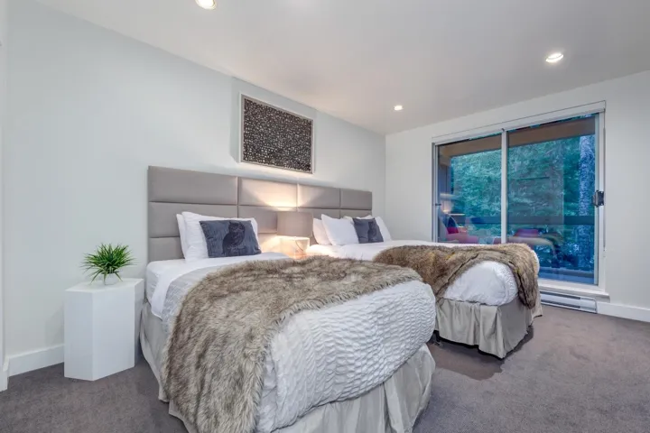 Bright room featuring a large sliding glass door, recessed lighting, and grey carpeting