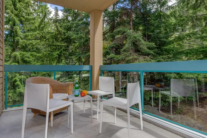 Outdoor balcony with glass panel railing and teal top rail