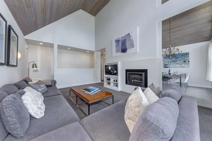 Vaulted ceilings with wood-finish paneling define this living area