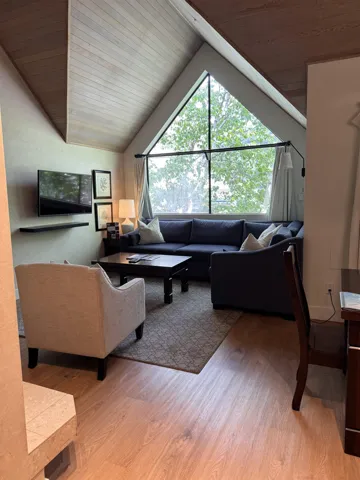 Living room with wood finished floors, lofted ceiling, and wooden ceiling