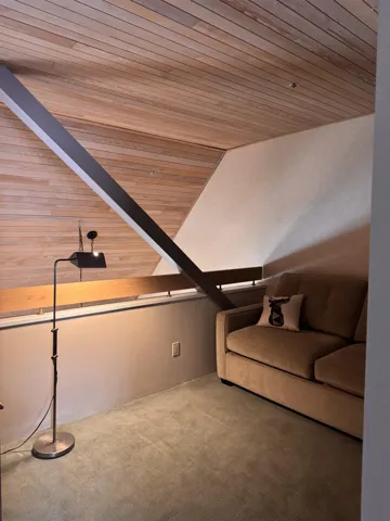 Unfurnished living room featuring wooden ceiling, carpet floors, and lofted ceiling