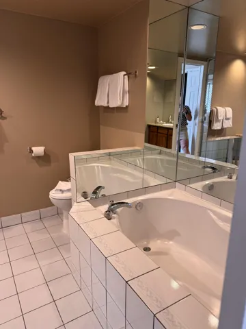 Bathroom with tile patterned floors, a garden tub, and vanity