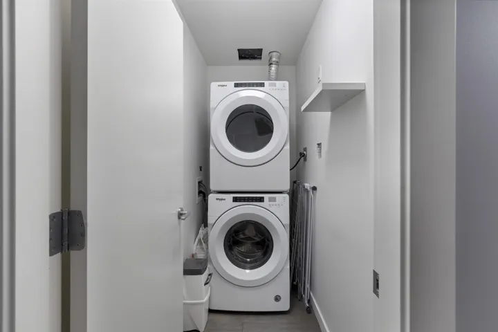 Laundry area featuring stacked washing machine and dryer