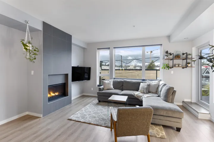Living room featuring a tiled fireplace and light wood-style floors