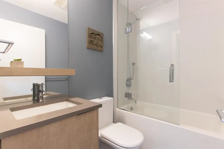 Bathroom featuring vanity and enclosed tub / shower combo