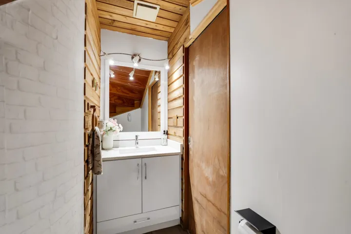 Half bath with a vaulted wooden ceiling and vanity