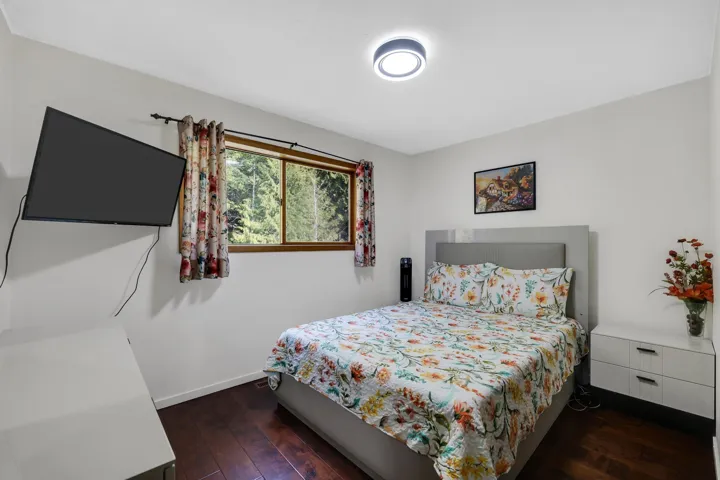 Bedroom featuring dark wood-style floors and baseboards