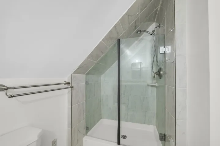 Bathroom featuring a stall shower and vaulted ceiling