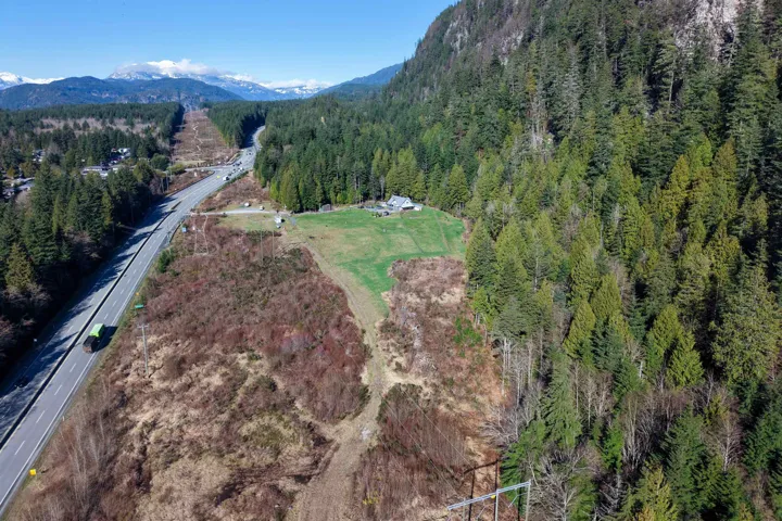 Drone / aerial view of a mountainous background and a heavily wooded area