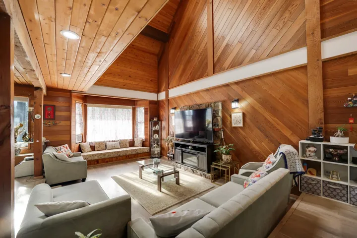 Living room with wooden walls, wood finished floors, recessed lighting, and a vaulted wooden ceiling