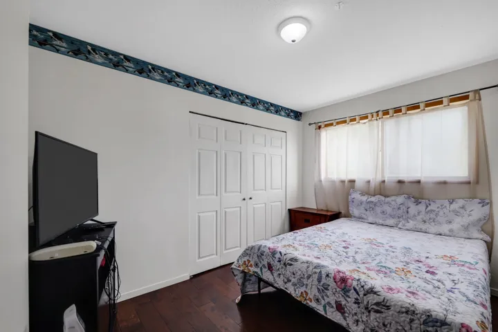 Bedroom featuring dark wood-type flooring and a closet