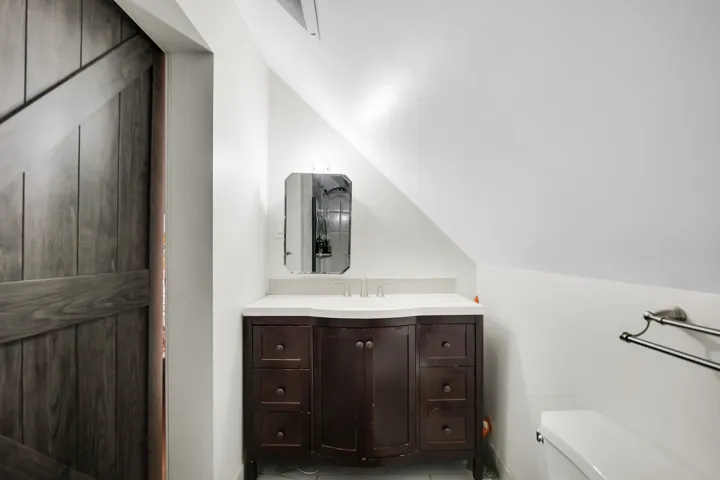 Bathroom featuring vanity and lofted ceiling