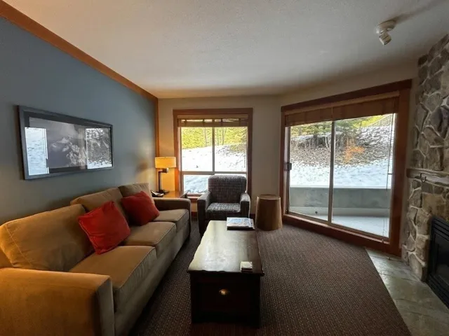 Living room with a fireplace, stone finish floors, and a textured ceiling
