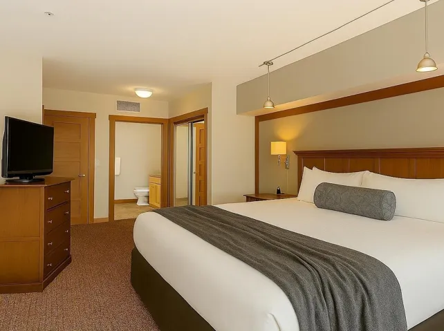 Bedroom with light colored carpet, a closet, and ensuite bathroom