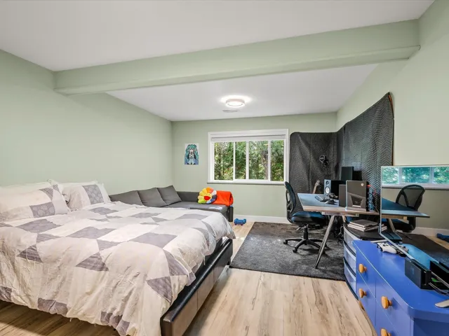 Bedroom featuring beam ceiling, baseboards, and light wood-style floors
