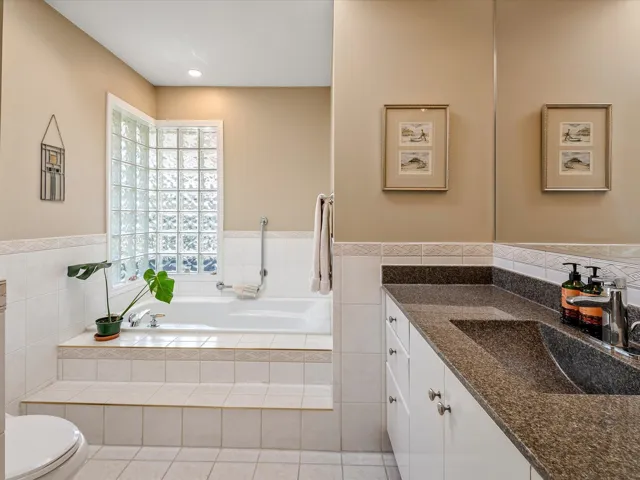 Full bathroom with vanity, a garden tub, toilet, and tile patterned floors
