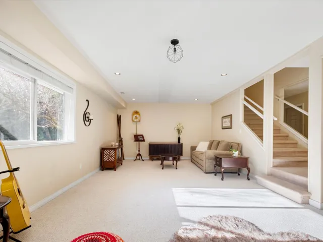 Carpeted living area with stairs, recessed lighting, and baseboards