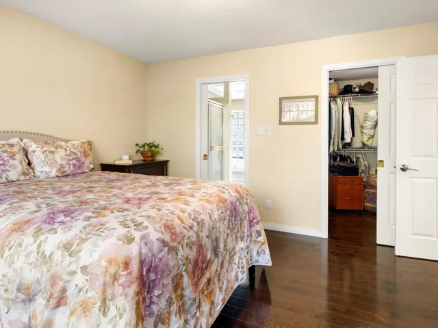Bedroom featuring a closet, baseboards, a walk in closet, and wood finished floors